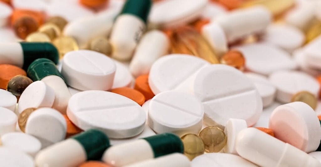 Close-up of various pills and capsules in different colors and sizes, ideal for healthcare-related content.