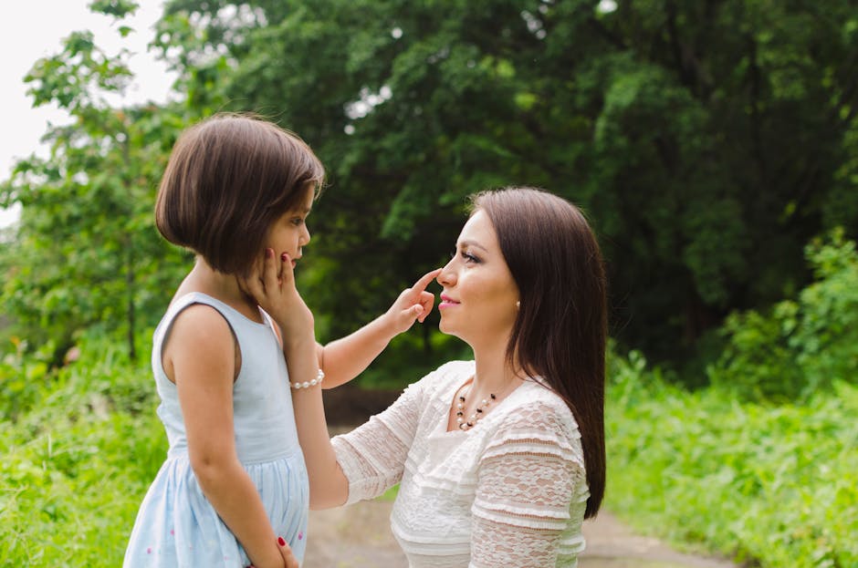 A loving interaction between a mother and daughter surrounded by lush greenery, showcasing a beautiful bond.