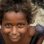 Close-up portrait of a smiling child with curly hair in Navi Mumbai, India.