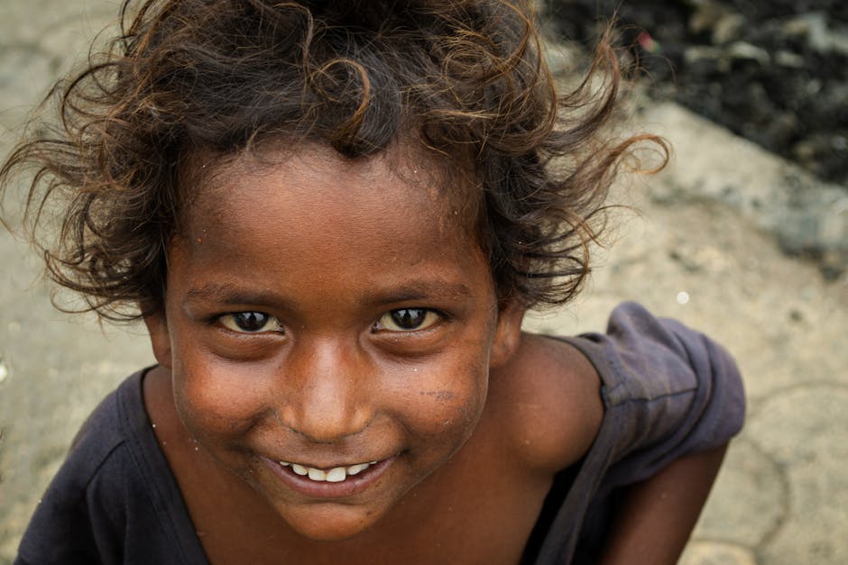 Close-up portrait of a smiling child with curly hair in Navi Mumbai, India.