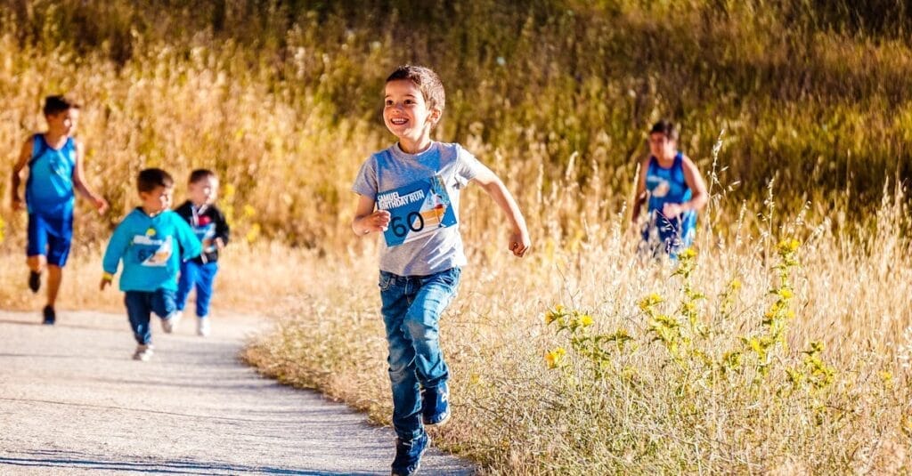 Children joyfully running in a park during a cheerful outdoor race event.