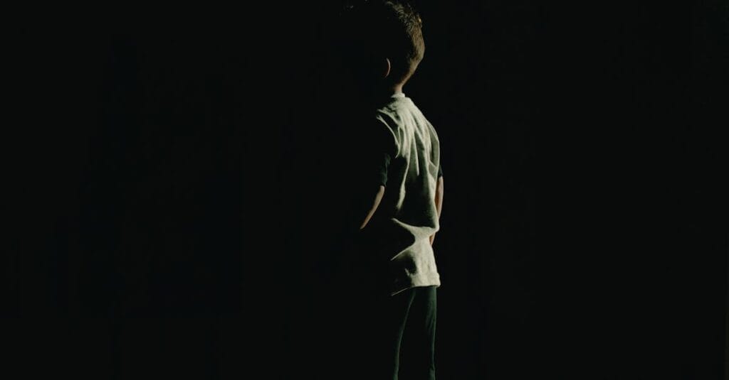 Silhouette of a child in a dark room, evoking mystery and intrigue.