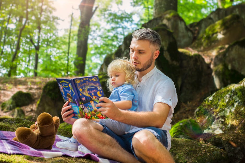 Father and toddler bonding over a book in a sunny forest setting.