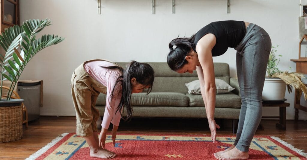 A mother and daughter practicing yoga in a cozy living room, promoting fitness and bonding.