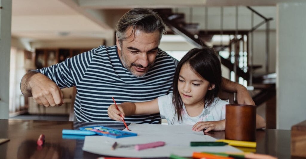 A father and daughter enjoying a crafting activity indoors. Creativity and bonding time.