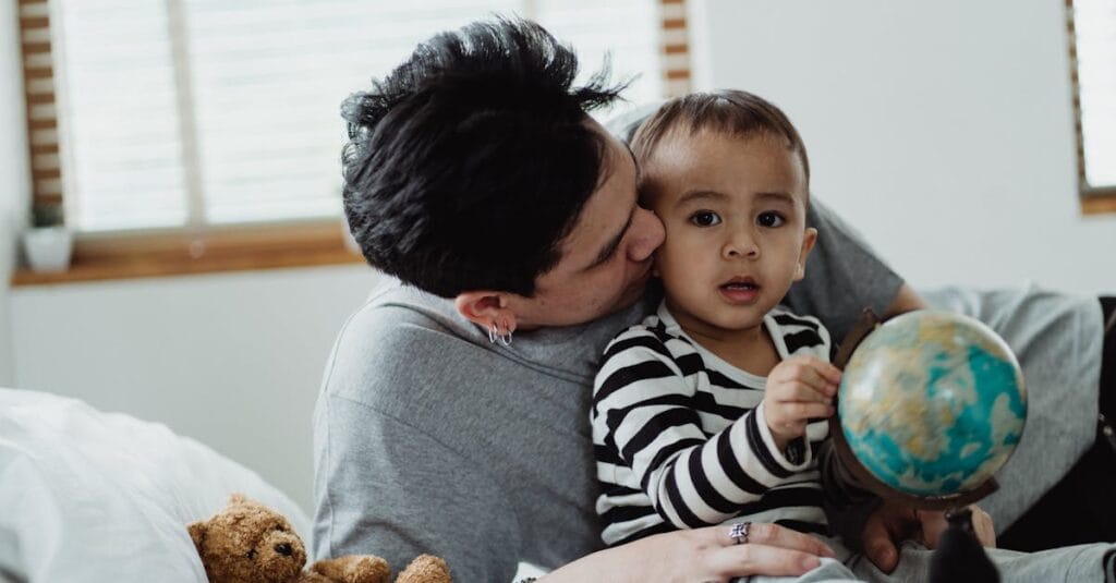 A touching moment of a father and son bonding indoors, exploring a globe together.