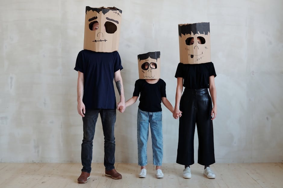 Family wearing cardboard monster masks for Halloween, showing creativity and fun.