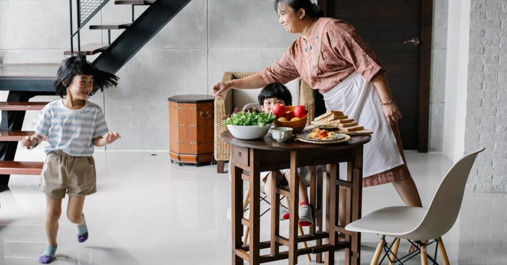 Joyful morning scene with grandma and kids having breakfast at home.