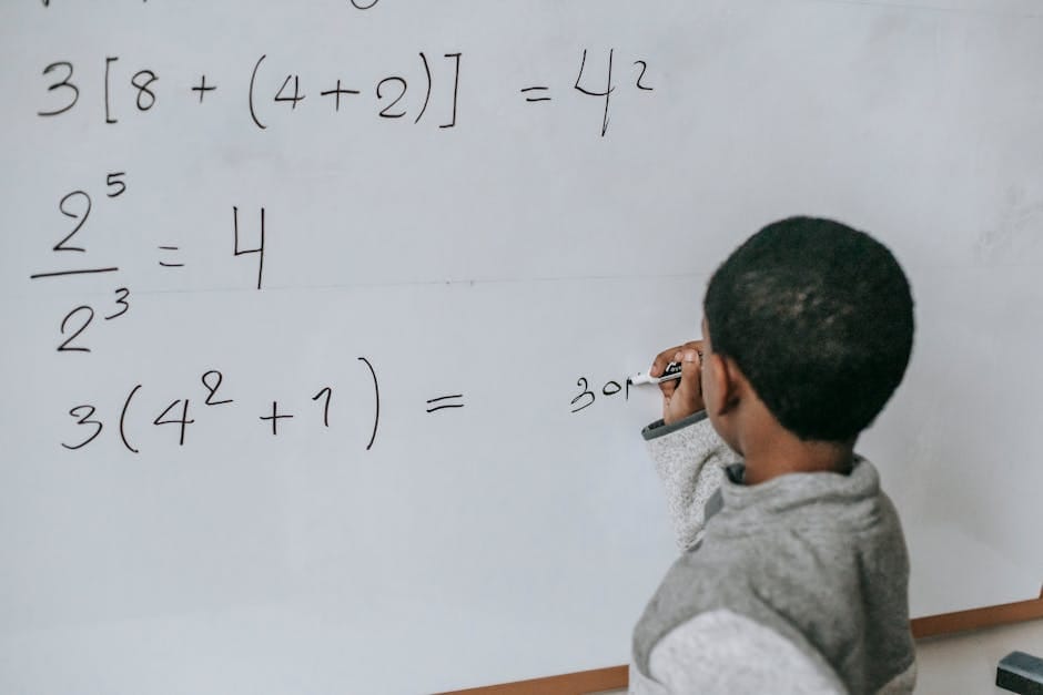 Focused child solving equations on a whiteboard, showcasing education and problem-solving skills.