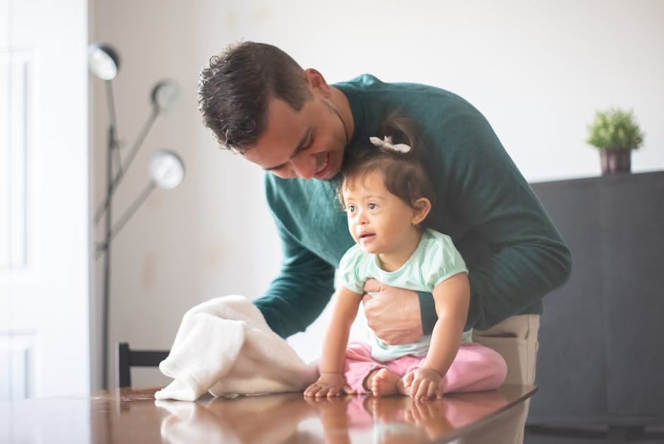 A loving father embraces his daughter with Down syndrome, highlighting family bonds at home.