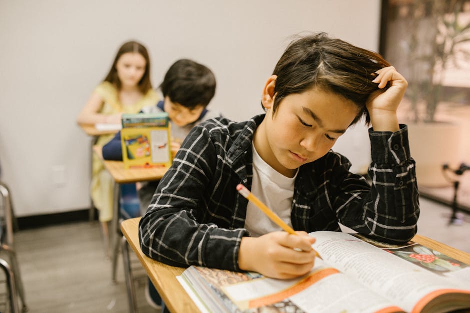 Students diligently working in a classroom, showcasing educational focus and concentration.