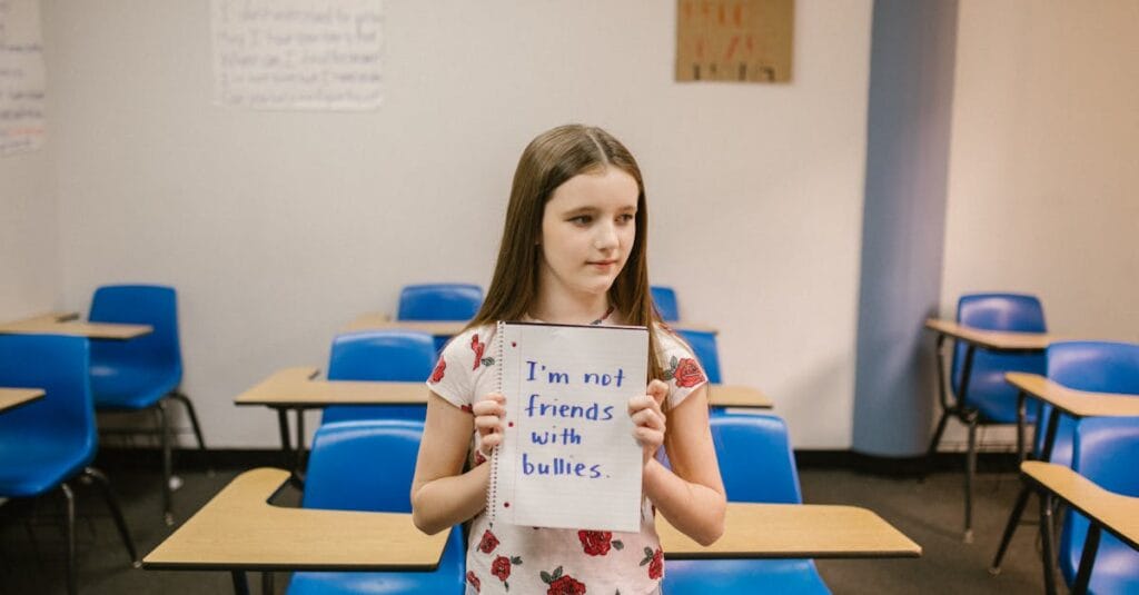 A girl stands in an empty classroom holding an anti-bullying sign.