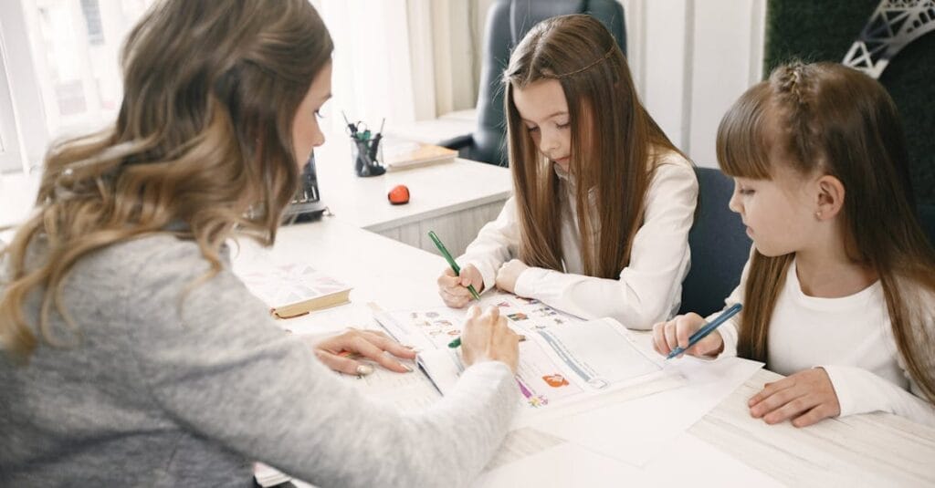 Woman teaching two girls in a bright office environment, focusing on an educational task together.