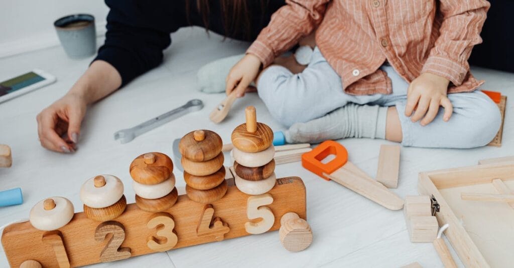 Young child playing with educational wooden toys indoors. Promotes creativity and learning.