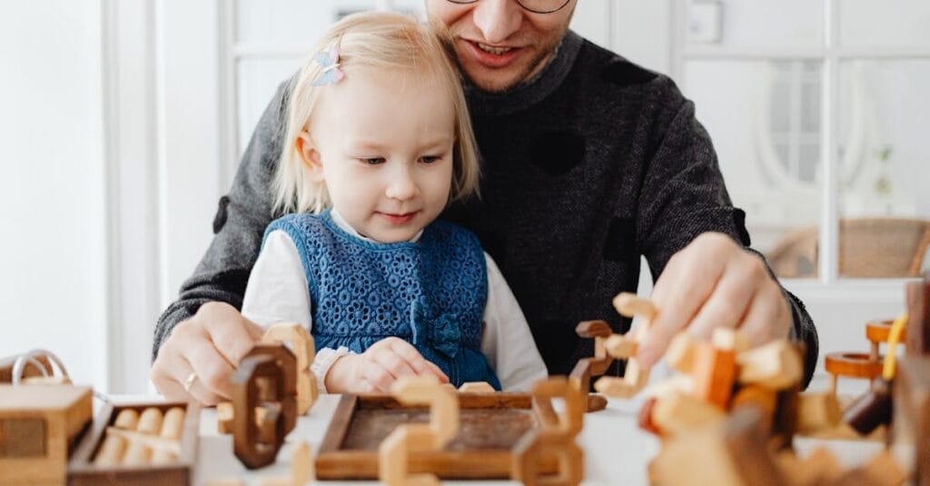 A father and daughter enjoying quality time playing with wooden toys indoors.
