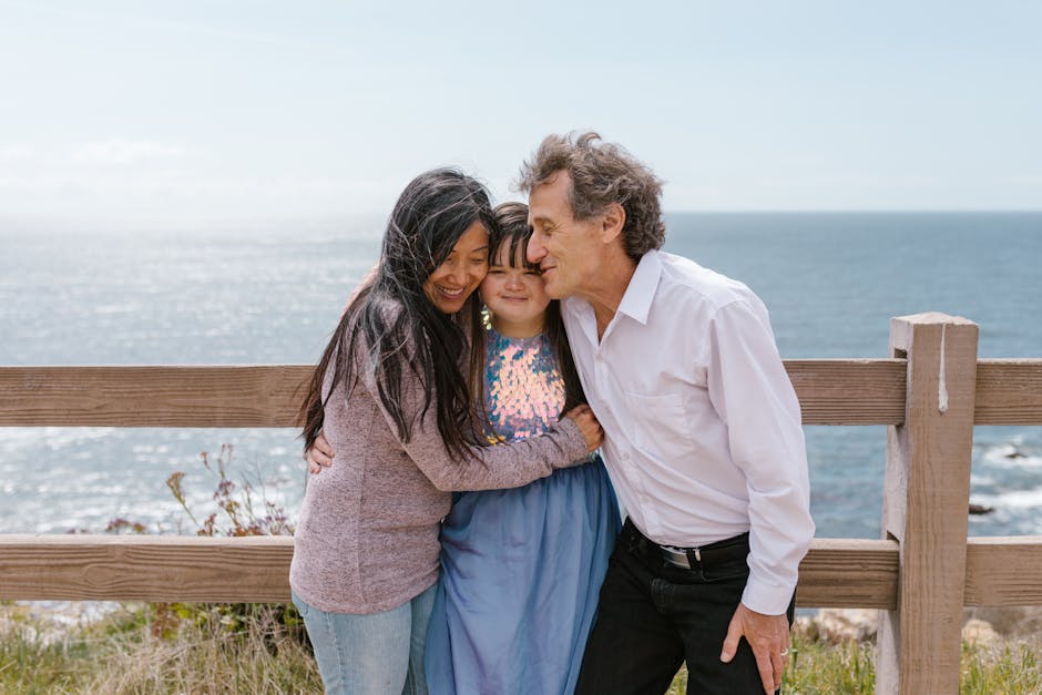 Family shares a loving embrace by the ocean, highlighting connection and joy.