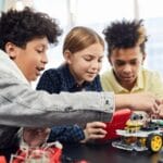 Children collaborating on an electronic robotics project, fostering teamwork and innovation.