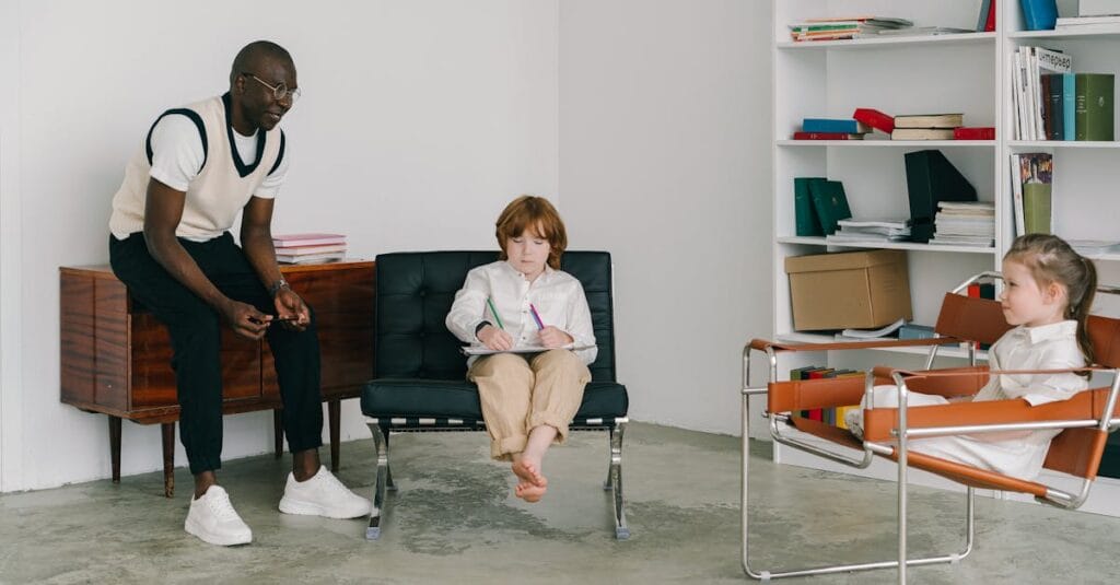 A teacher guides children in a classroom with books and modern chairs, fostering education and development.