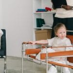 Children engage in a therapy session while the therapist observes with a clipboard.
