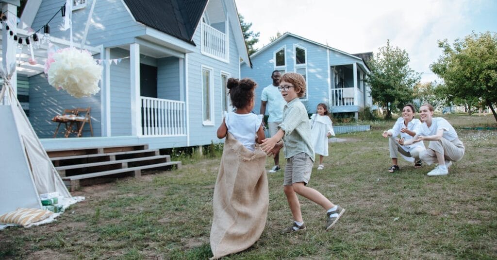 Children and adults enjoying a lively sack race in the yard during a family celebration.