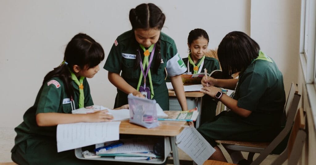 A group of girls in school uniforms studying together in a classroom setting.