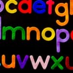 Vibrant alphabet letters arranged against a dark background for educational use.