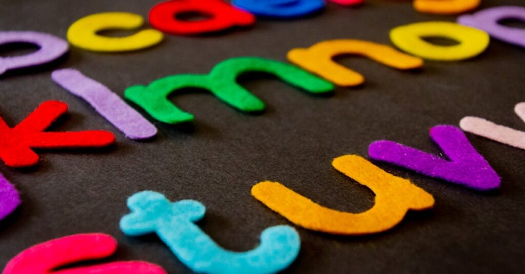 Bright and colorful felt alphabet letters arranged on a dark surface, perfect for educational and creative projects.