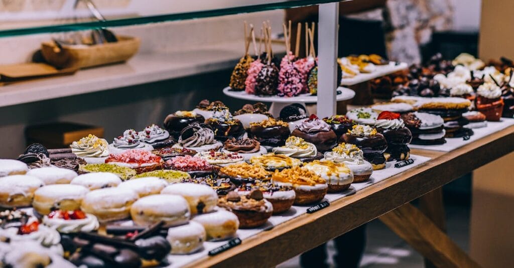 A tempting display of various donuts and pastries in a bakery. Ideal for food lovers and culinary enthusiasts.
