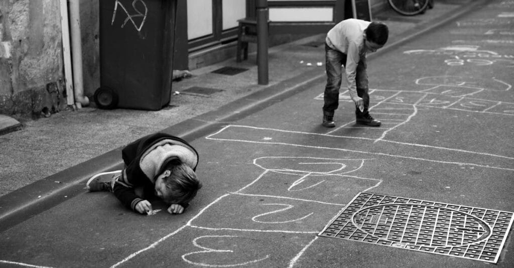 Two children play hopscotch with chalk on a street in La Rochelle, France.