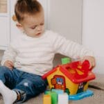 Young boy engages with colorful educational toy inside a cozy home environment.