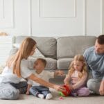 Family bonding time on the carpet in a cozy living room setting.