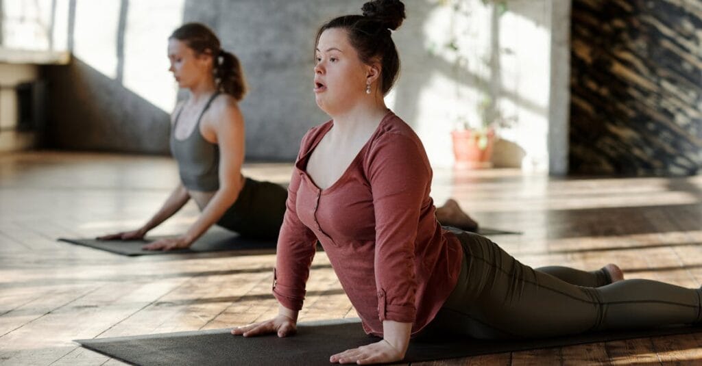 Women practicing yoga indoors, focusing on wellness and inclusion.