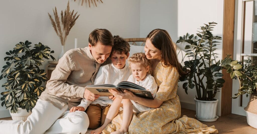 A joyful family shares a book indoors, surrounded by houseplants, promoting reading and togetherness.