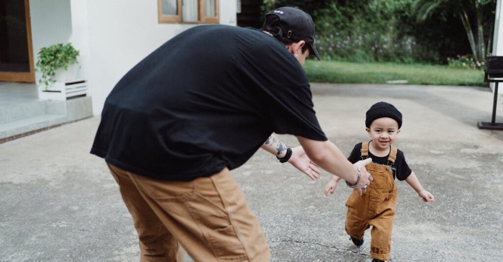 Joyful father and son bonding while playing outside their home. Capturing family happiness.