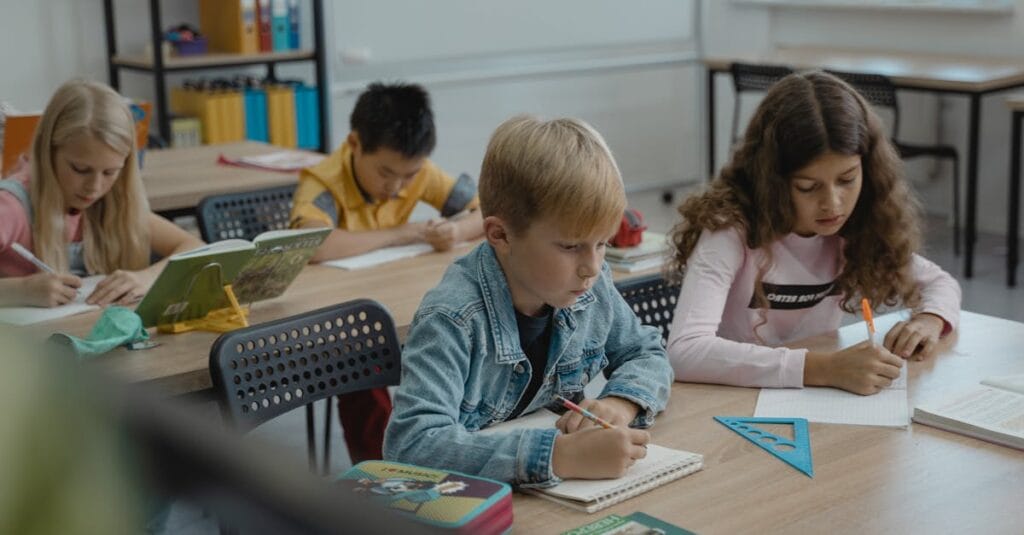 A group of children focused on studying in a classroom with books and stationery.