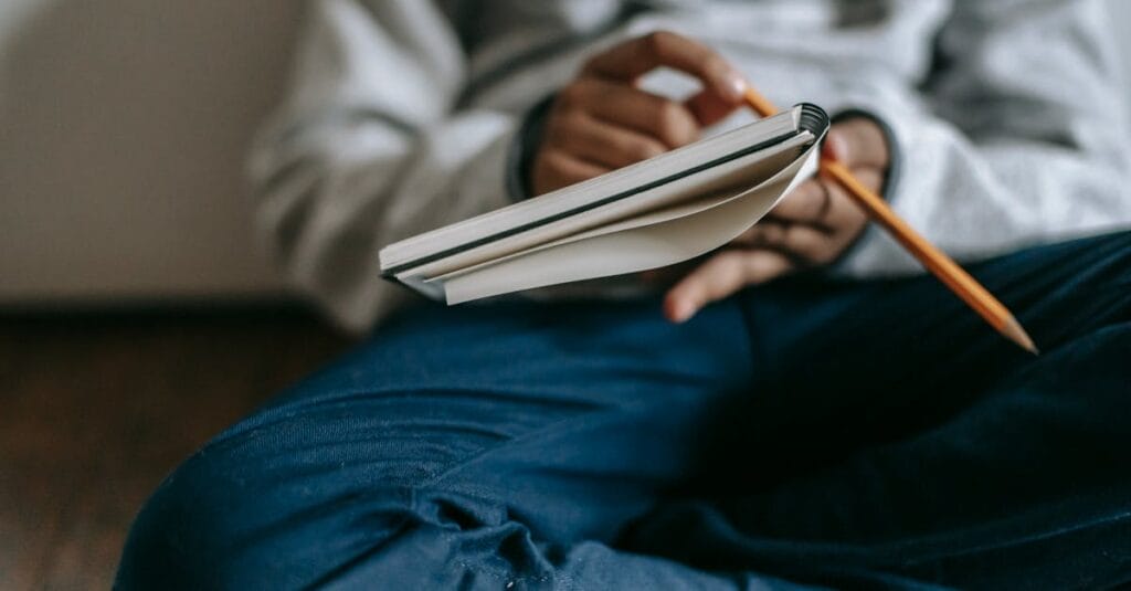 A child attentively writing in a notebook, captured in a cozy home environment, emphasizing learning and creativity.