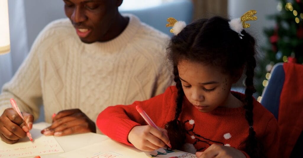 Father and daughter enjoying a creative moment, making Christmas cards together.