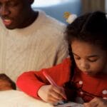 Father and daughter enjoying a creative moment, making Christmas cards together.