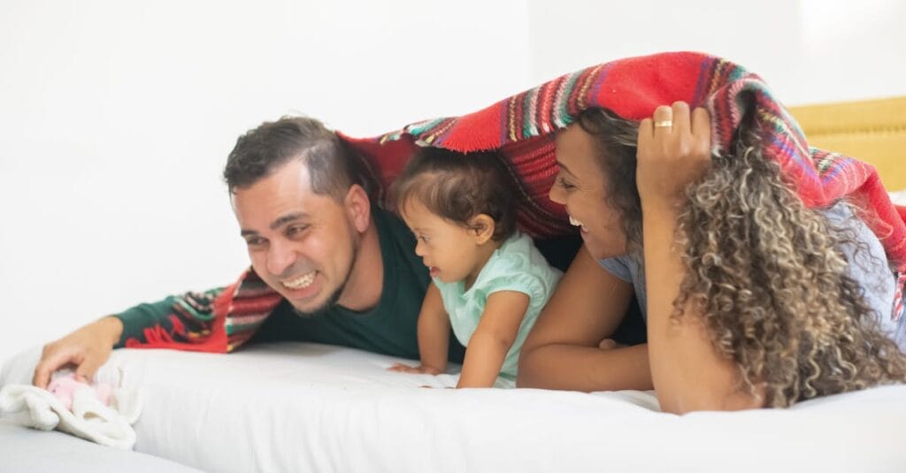 Happy family enjoying playful moments under a blanket, capturing warmth and affection.