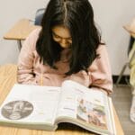 Students focused on their studies in a classroom, promoting education and learning.