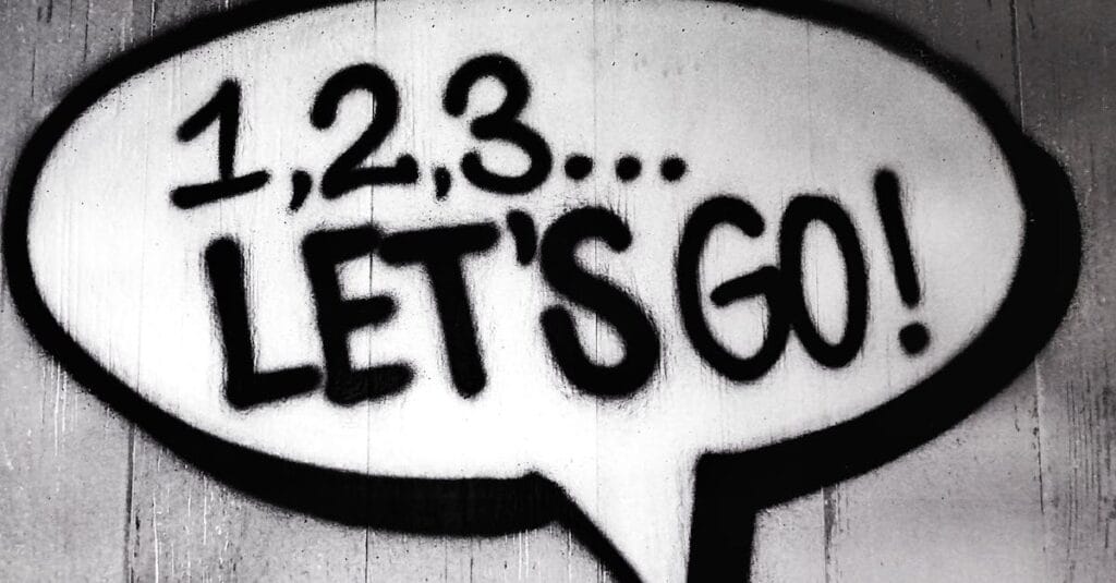 Black and white street art featuring a bold motivational message in a speech bubble.