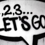Black and white street art featuring a bold motivational message in a speech bubble.