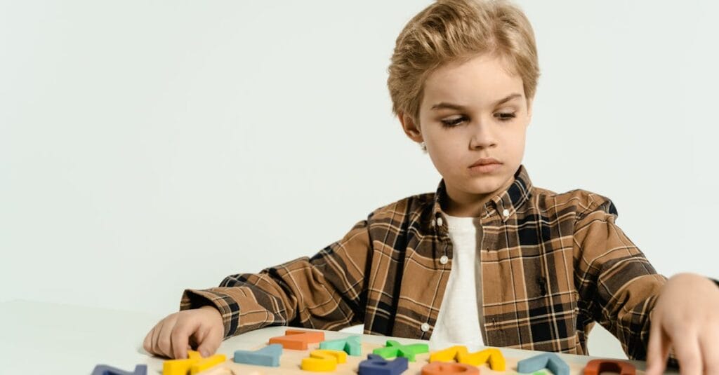 A young boy concentrates on assembling a colorful alphabet puzzle indoors, promoting educational play.