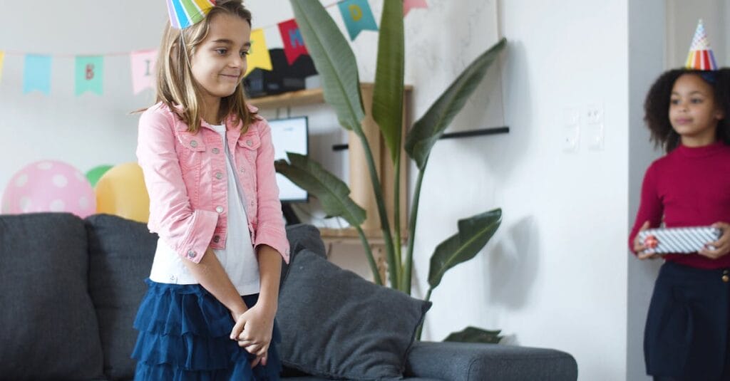 Cheerful children celebrating a birthday party indoors with colorful decorations in Portugal.