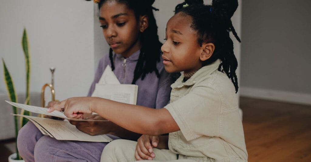 Two young sisters engaged in reading sheet music indoors, promoting education and togetherness.