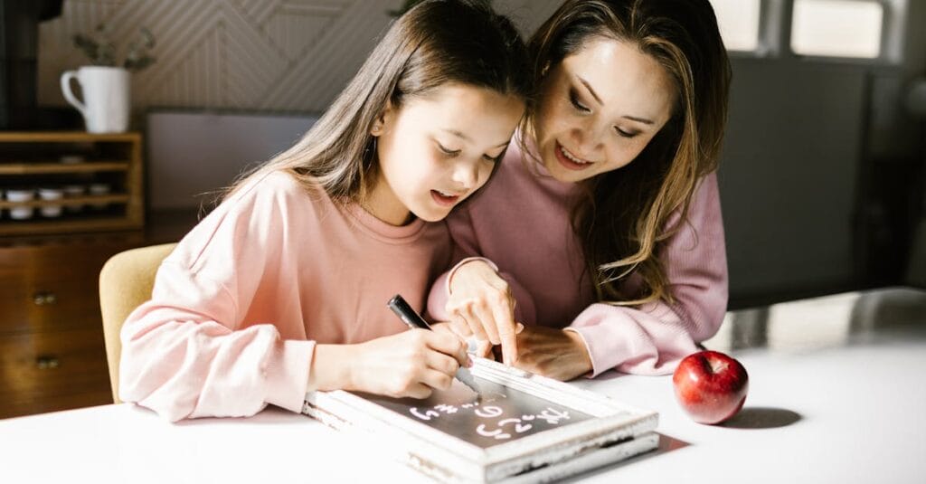 A mother and daughter collaborate on a school project at the kitchen table, fostering learning and creativity.
