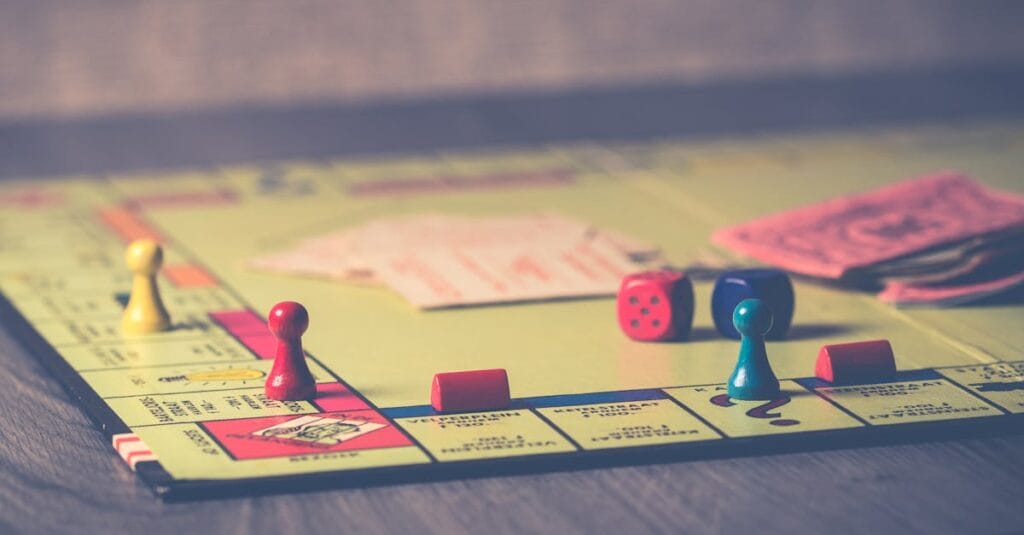 A close-up of a Monopoly board game with pieces and dice scattered around.