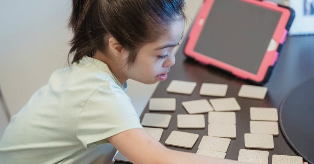 A young girl intently plays a memory card game indoors, showcasing focus and concentration.