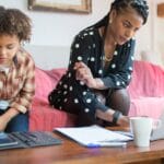 A woman and her son using technology in a cozy living room setting.