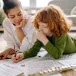 A mother and child study music sheets together at home with a flute. Warm and educational setting.